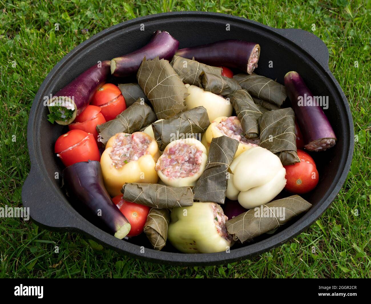 Paprika, Auberginen, Tomaten und Traubenblätter gefüllt mit der Fleisch-Reis-Füllung zum Kochen Dolma. Gefülltes Gemüse in der großen Pfanne im Freien. Farbe Stockfoto