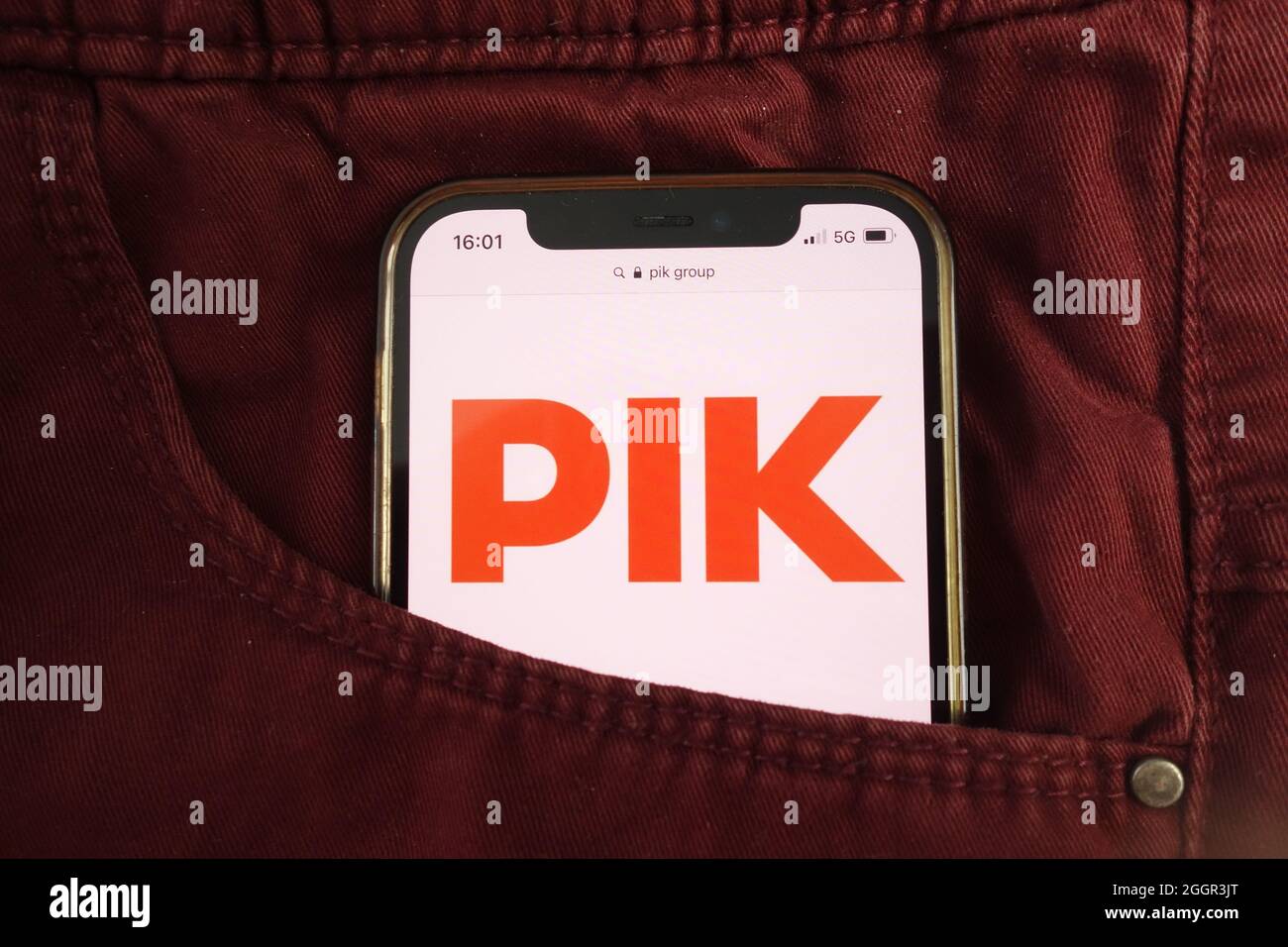 KONSKIE, POLEN - 17. August 2021: Das Logo der PIK-Gruppe wird auf dem Mobiltelefon in der Jeans-Tasche versteckt angezeigt Stockfoto