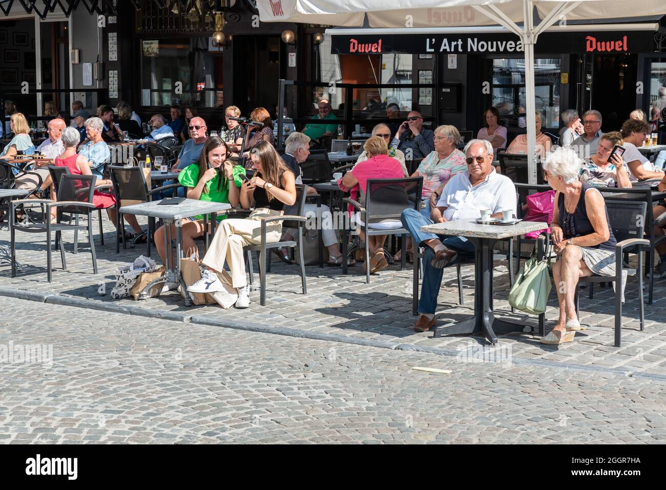 Menschen sitzen im Sommer auf einer sonnigen Terrasse am Hauptmarkt Stockfoto