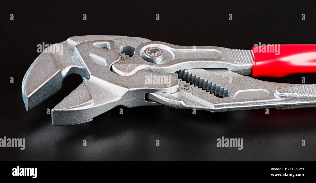 Detail aus Metall verstellbaren Schraubenschlüssel mit Reflexion auf einem schwarzen Hintergrund. Nahaufnahme einer Flachzange mit Nut und Feder aus Stahl im künstlerischen Stillleben. Stockfoto