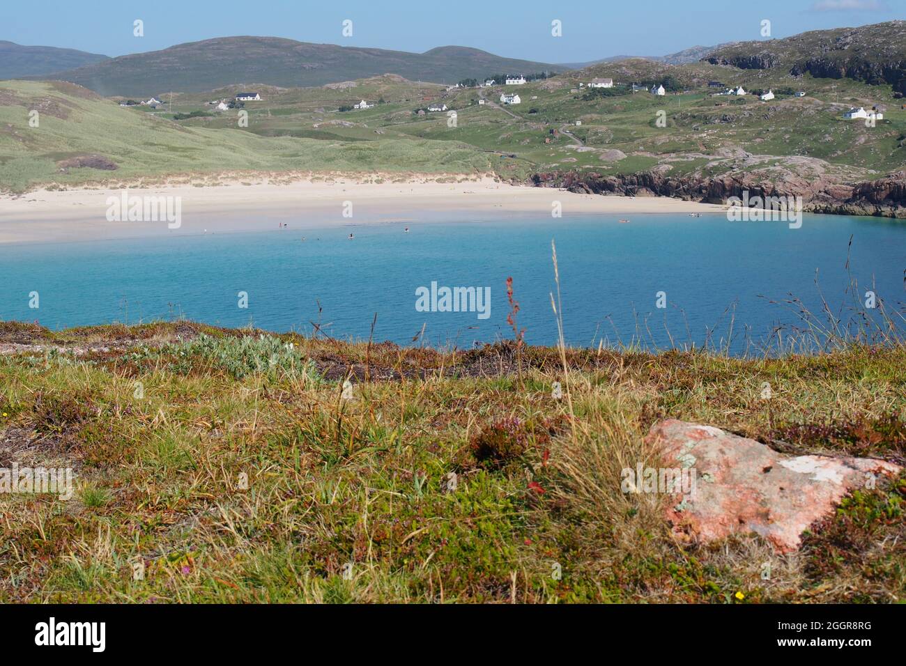 Ein Blick zurück auf Oldshoremore Beach, Kinlochbervie, Schottland, von einer Landzunge im Meer an einem hellen, heißen, sonnigen Tag Stockfoto