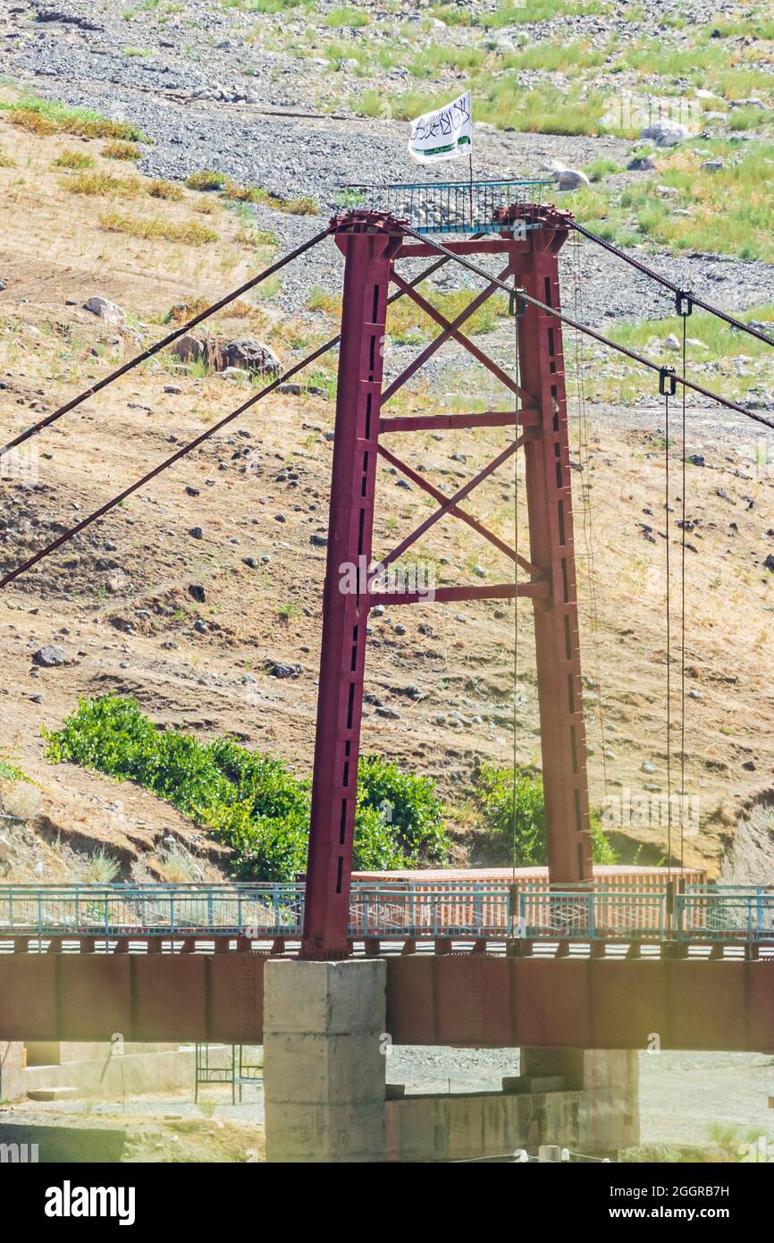 Provinz Khatlon, Tadschikistan. 13. August 2021. Taliban flaggen auf einer Brücke über den Panj-Fluss, die Tadschikistan und Afghanistan trennt. Stockfoto