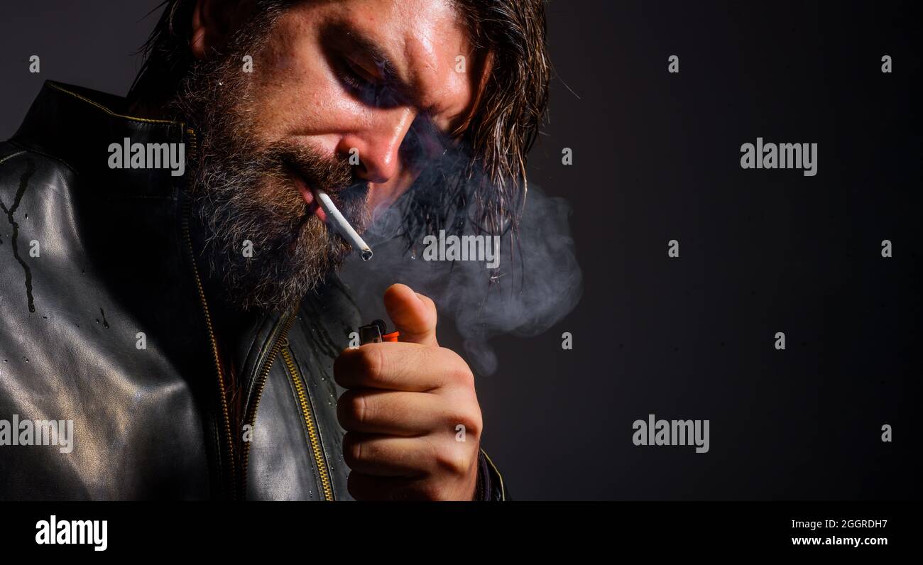 Rauchender Mann. Bärtiger Mann zündet Zigarette an. Schlechte Gewohnheiten. Modischer Kerl rauchen Zigarette. Nahaufnahme. Stockfoto