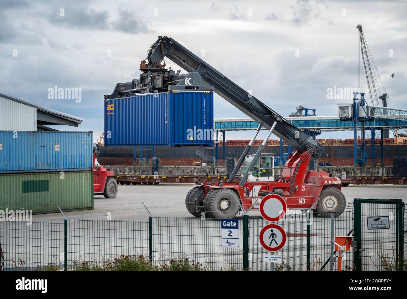 Sassnitz-Mukran, 20. August 2020: Rotes Rangierfahrzeug bewegt einen schweren blauen Container im Industriefrachthafen Sassnitz Mukran am Th Stockfoto