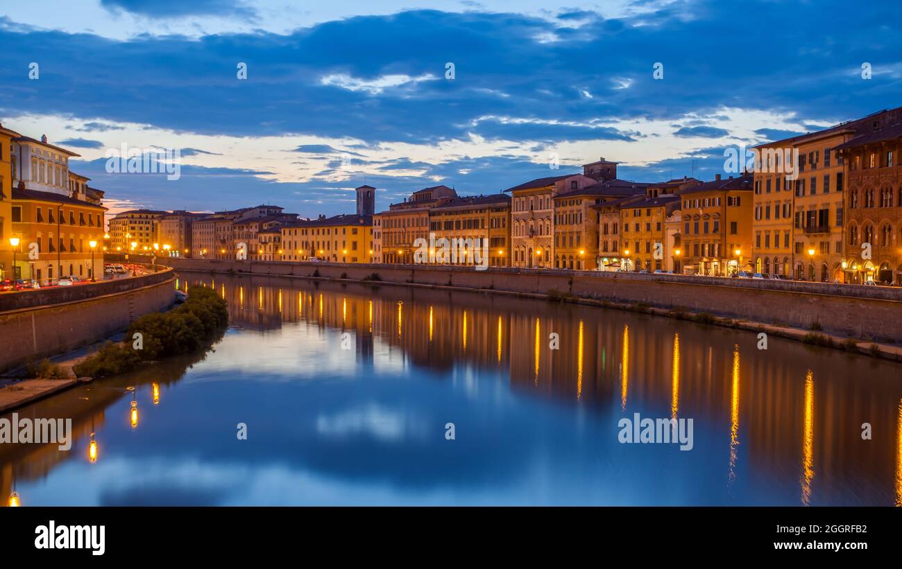 Stadt Pisa und Fluss Arno in der Abenddämmerung, Italien. Nächtliches Stadtbild Stockfoto