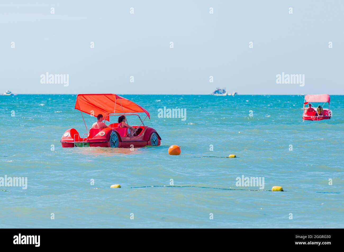 Ukraine, Iron Port - 27. August 2020: Zwei Erwachsene Frauen und Männer, die Urlaub machen, fahren mit einem Wasserrad-Katamaran auf dem blauen Meer. Stockfoto