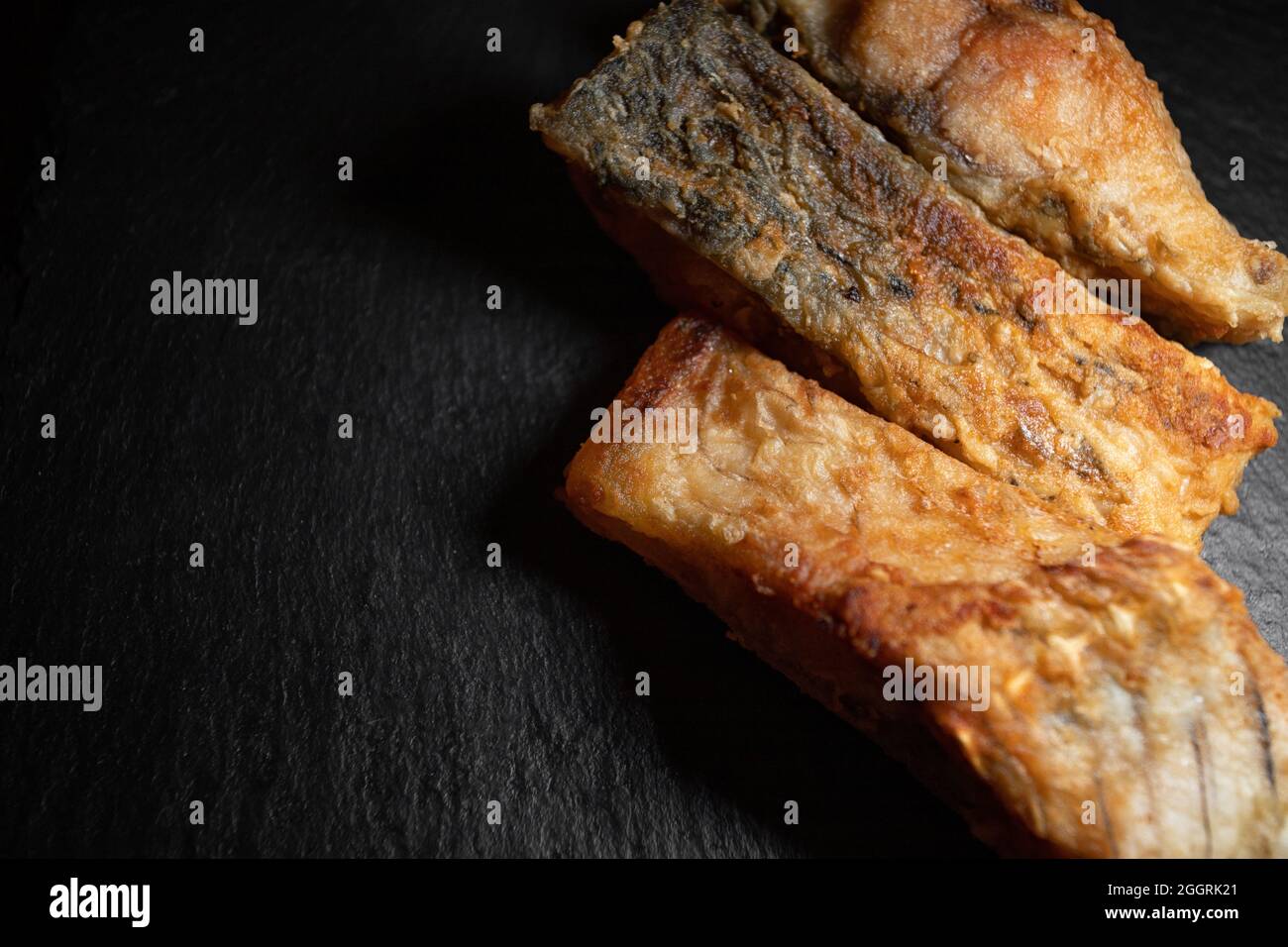 Drei gebratene Karpfenfische auf schwarzem Hintergrund Stockfoto