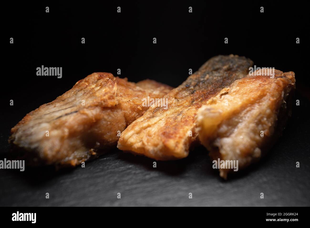 Drei gebratene Karpfenfische auf schwarzem Hintergrund Stockfoto