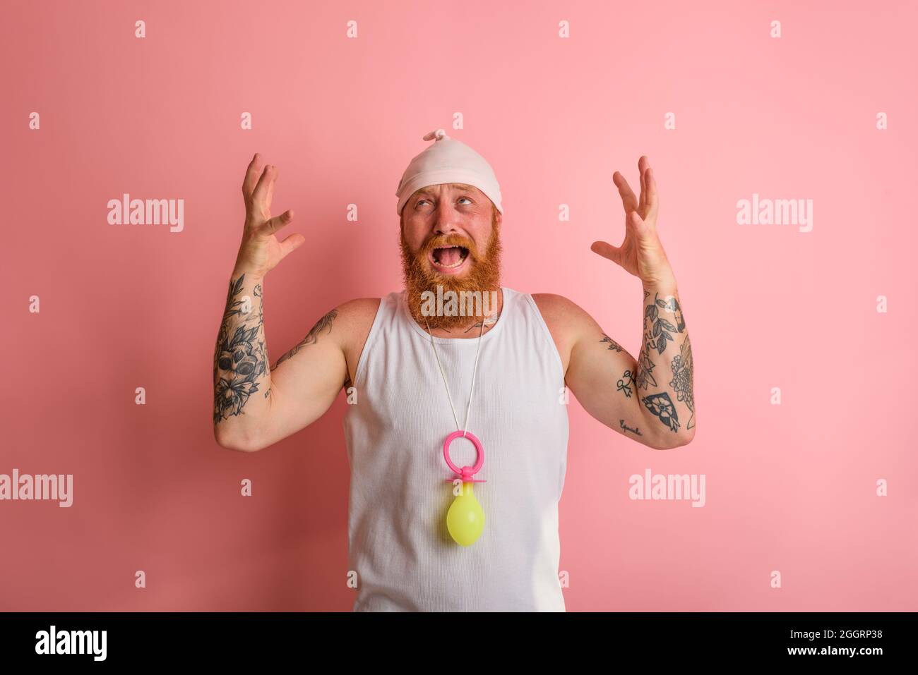 Cry Mann mit Bart und Tattoos wirkt wie ein kleines Neugeborenes Stockfoto