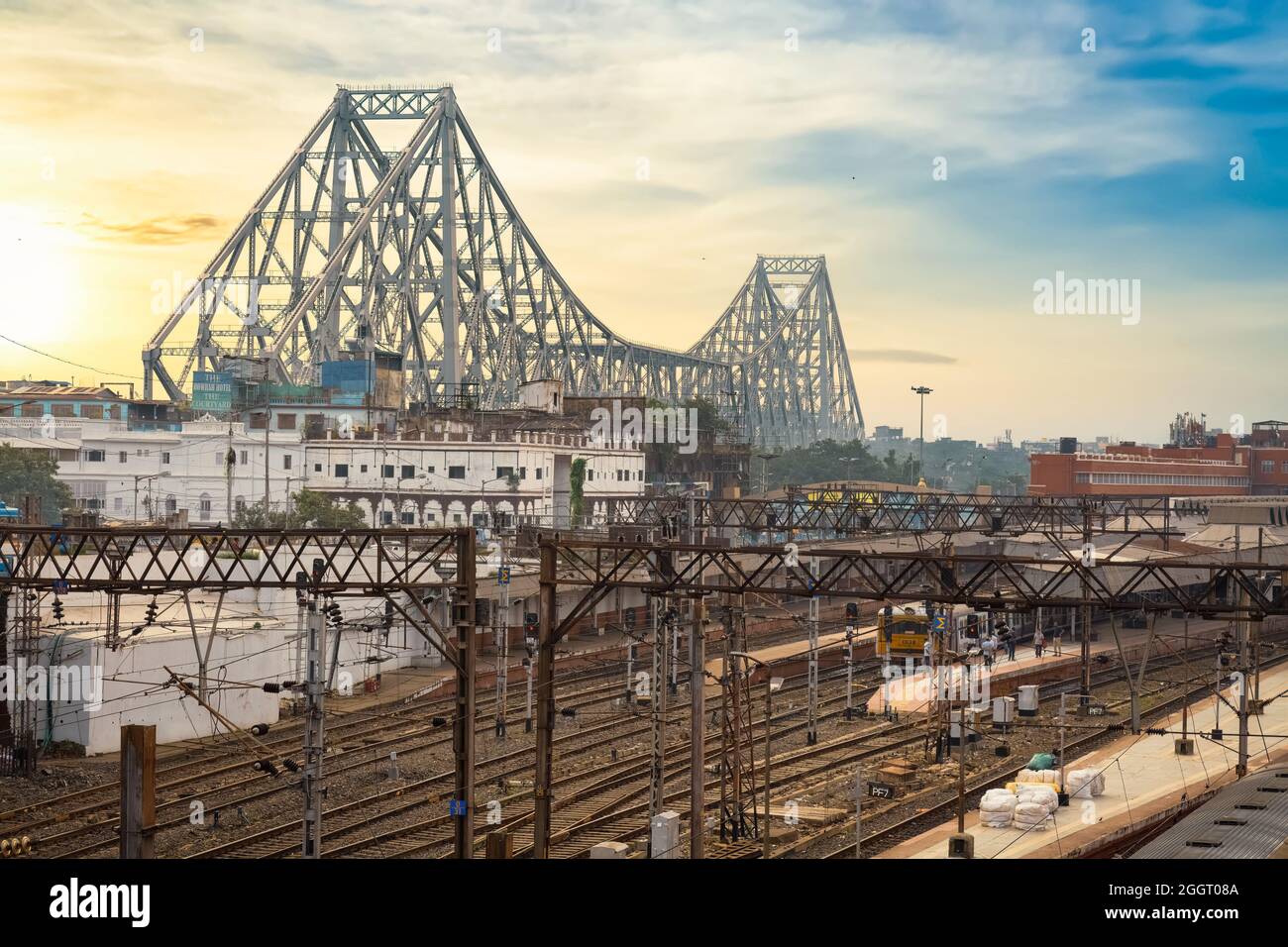 Howrah-Brücke mit Blick auf die Bahngleise des Howrah-Bahnhofs und das Stadtbild von Kalkutta bei Sonnenaufgang. Stockfoto