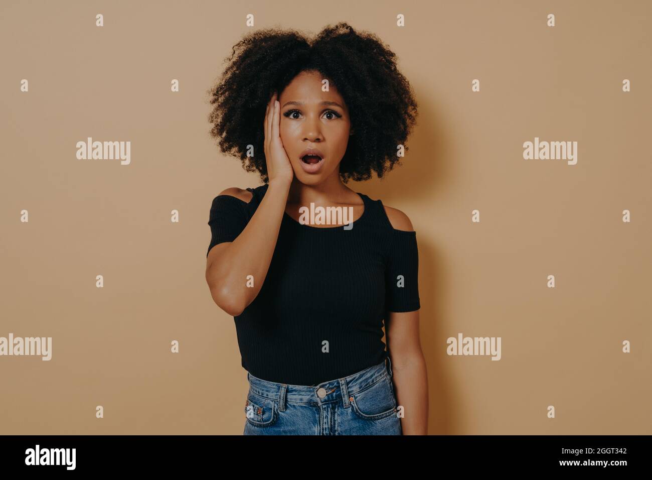 Studioportrait einer jungen, schockierten afrikanischen Frau mit unerwartetem Gesichtsausdruck Stockfoto