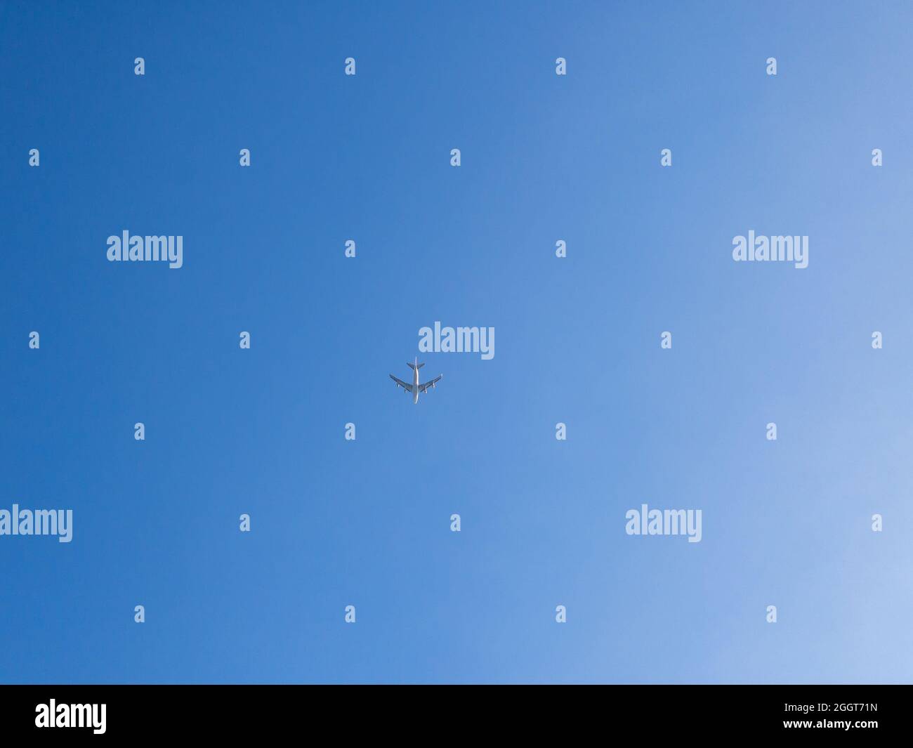 Ein Passagierflugzeug, das über den Kopf fliegt. Jet-Flugzeug, das tief mit blauem Himmel und Wolken im Hintergrund fliegt. Flugzeug fliegen in Tageszeit Stockfoto