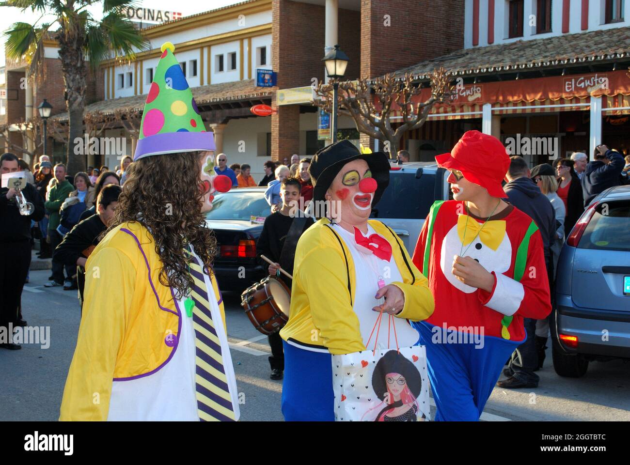Drei Clowns mit Tüten Süßigkeiten führten die Parade der drei Könige durch die Stadt, La Cala de Mijas, Andalusien, Spanien. Stockfoto