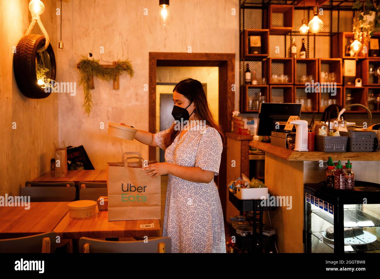 Berlin, Deutschland. September 2021. Ein Mitarbeiter des Restaurants ETE im Bezirk Friedrichshain packt eine Tragetasche für den Lieferservice Uber isst. Quelle: Carsten Koall/dpa/Alamy Live News Stockfoto