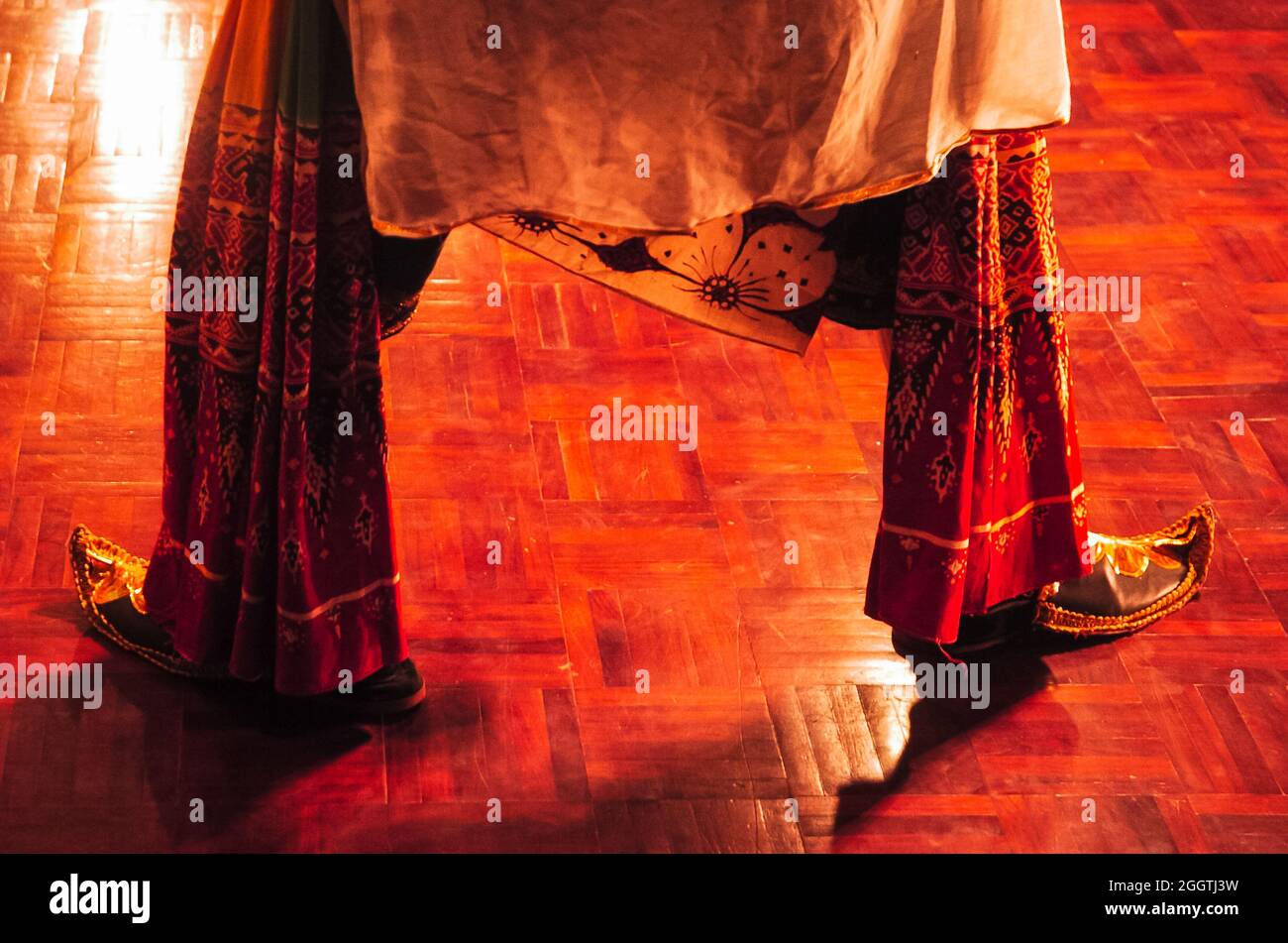 Ein Paar Füße eines Puppenschauspielers oder Pemain Wayang orang, in Schuhen und stehend auf der Bühne. Stockfoto