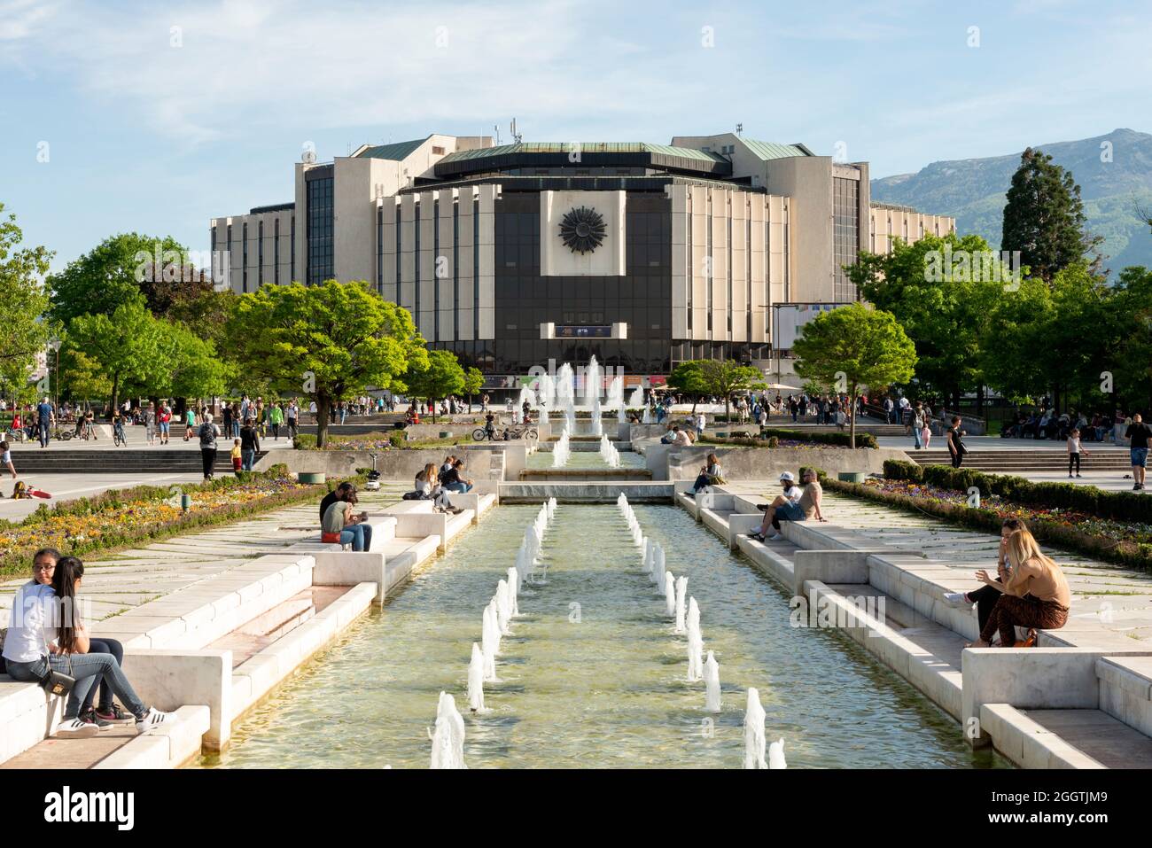 Sofia Bulgarien Blick auf die Menschen an den Brunnen des ikonischen Gebäudes des Nationalen Kulturpalastes oder NDK Stockfoto