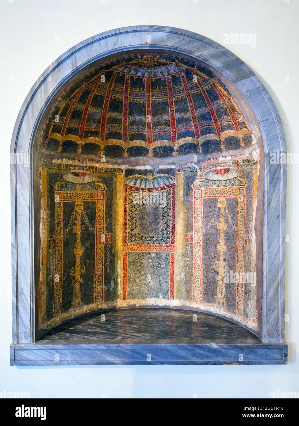 Nische eines Nymphäums. Nische ist in der Wand eines Nymphäums, mit polychromer Glaspaste tesserae bedeckt gesetzt. Die Trommel der Nische ist in Form einer Muschelschale dekoriert, während die Wände mit Paneelen geschmückt sind, die Kränze zeigen. Herculaneum, Casa dello Scheletro (Haus des Skeletts). Drittes Viertel des 1. Jahrhunderts n. Chr. Stockfoto