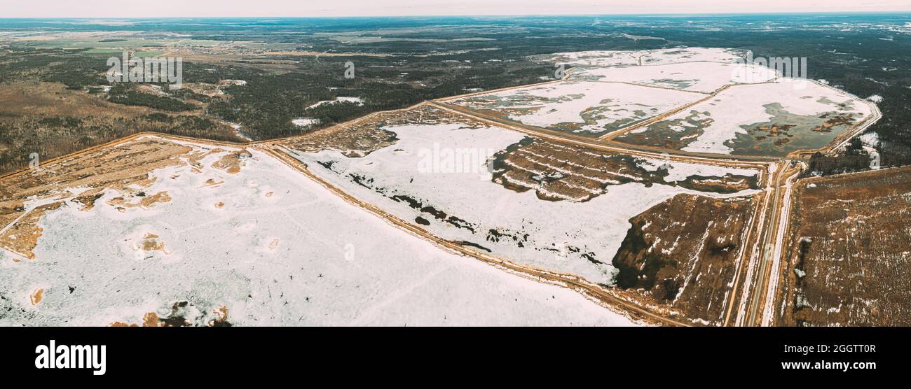 Luftaufnahme Der Straße Durch Teiche In Der Winterverschneiten Landschaft. Gefrorene Teiche Der Fischerei Im Süden Von Weißrussland. Blick Von Oben Auf Fischfarmen Von High Attitude Stockfoto