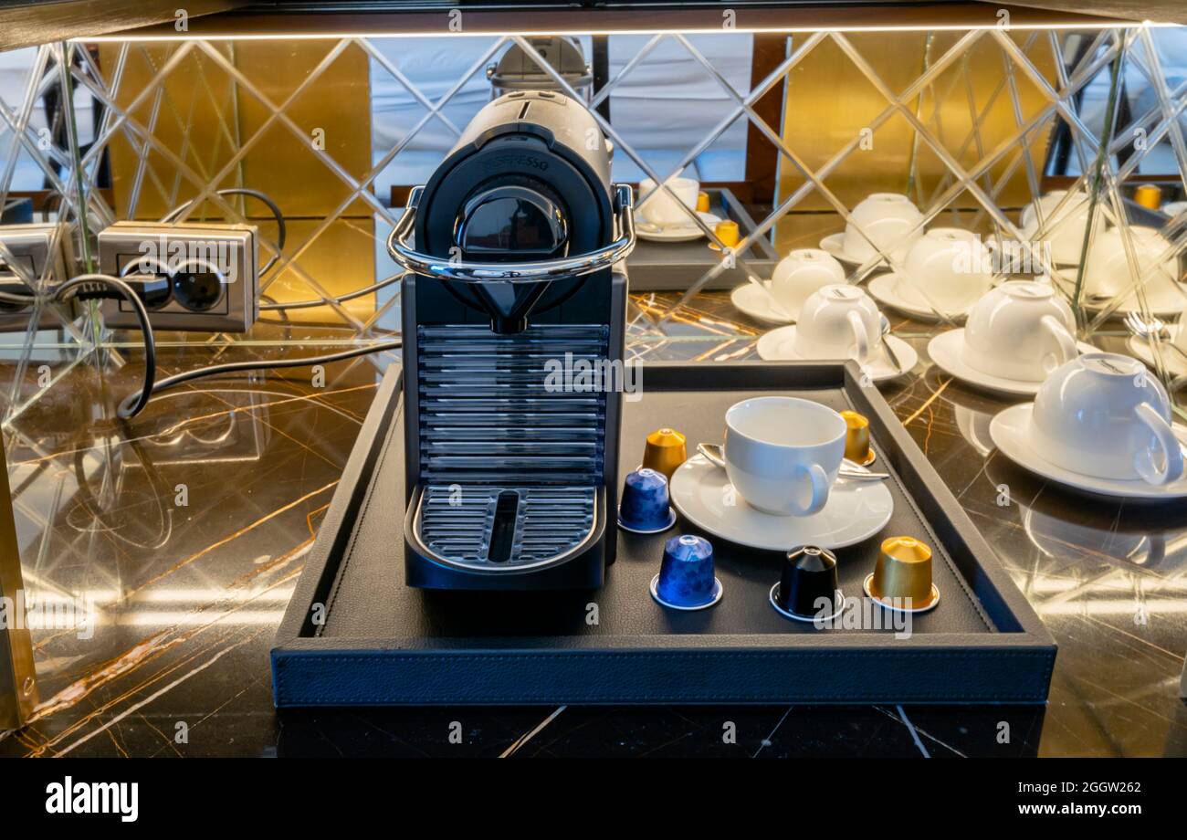 Espressomaschine und Station mit Tassen im Zimmer des Hotels Stockfoto