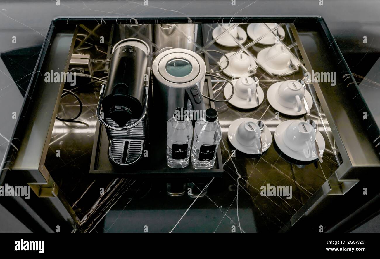 Espressomaschine und Station mit Tassen und Markenwasserflaschen in der Minibar des Ritz Carlton Hotels Stockfoto
