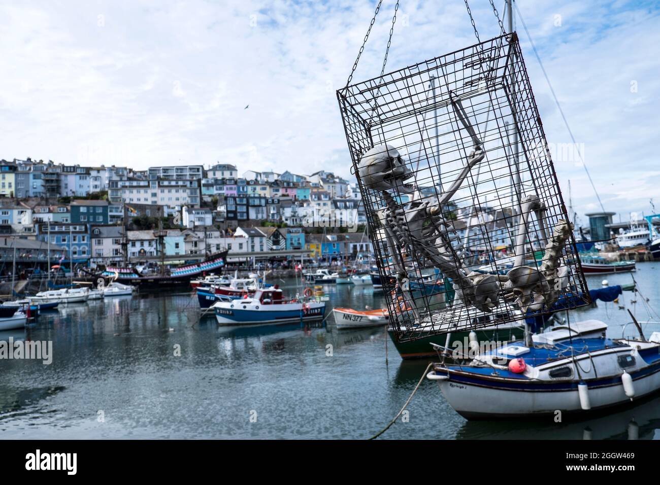 Ein Skelett in einem Käfig, das über dem Hafen in Brixham, Devon, aufgehängt ist Stockfoto