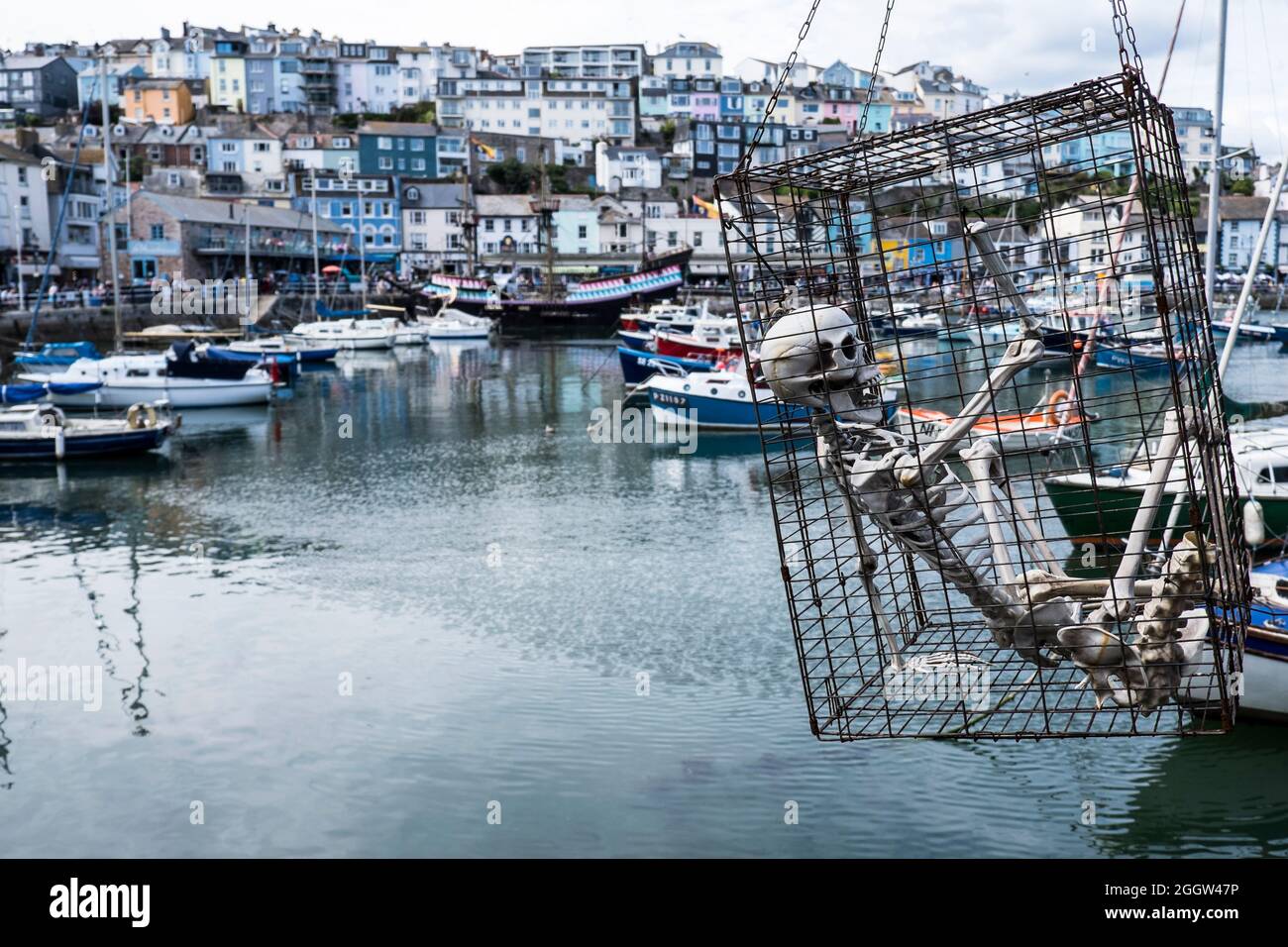 Ein Skelett in einem Käfig, das über dem Hafen in Brixham, Devon, aufgehängt ist Stockfoto