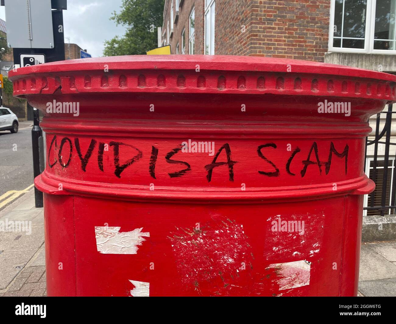 Covid ist ein Scam-Graffiti, das auf einem Briefkasten geschrieben wurde. Coronavirus-Verschwörung Stockfoto