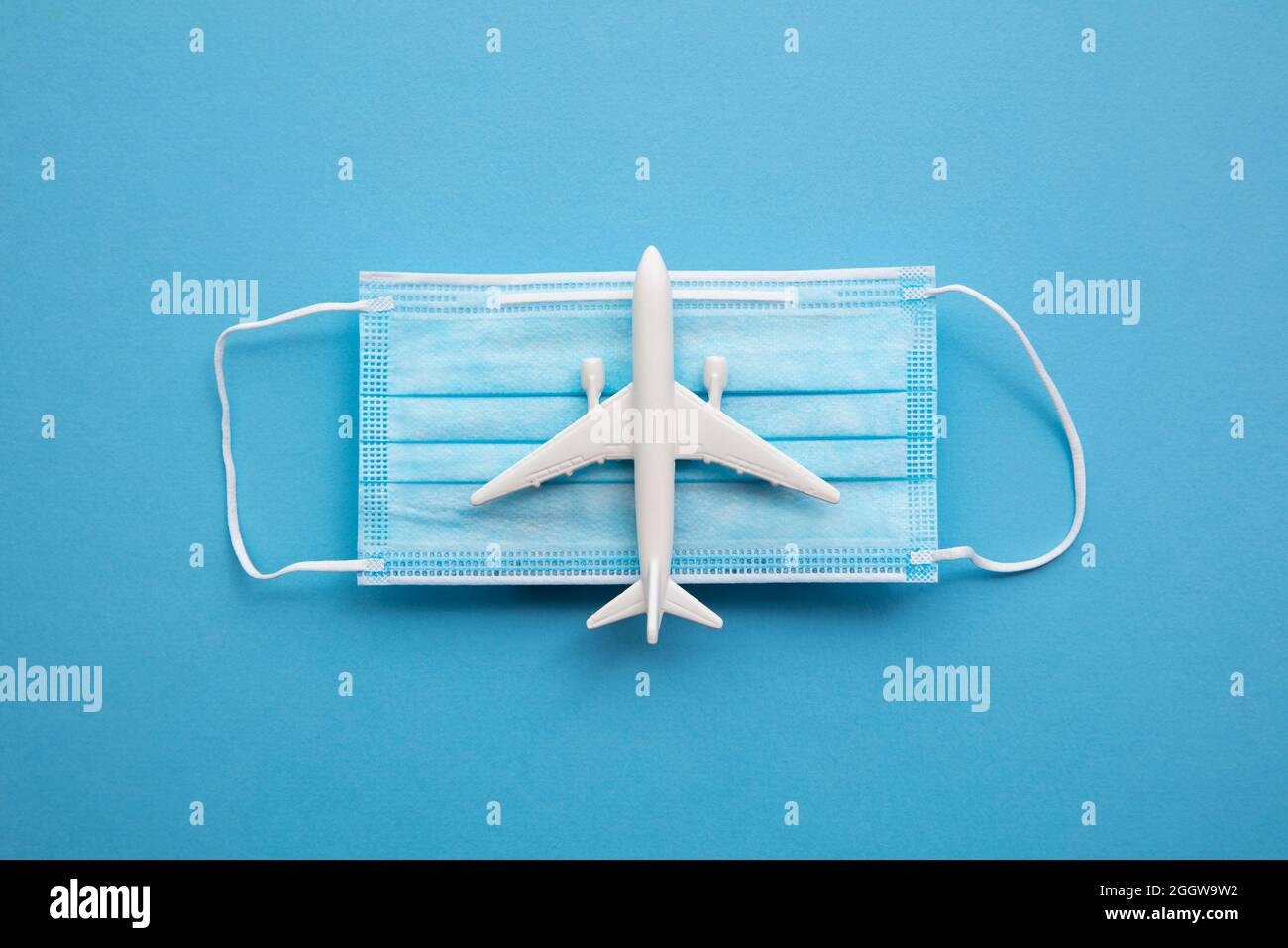Covid Flugreisen Hintergrund. Flugzeug mit einer Coronavirus-Schutzmaske Stockfoto