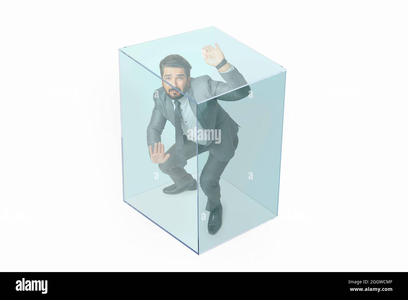 Porträt eines Mannes in formellem Business-Anzug in einem transparenten Würfel gefangen. Stockfoto