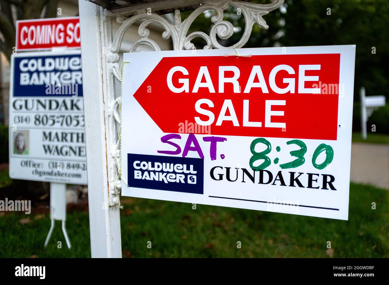 Schilder, die ein Haus zum Verkauf und eine bevorstehende Garage verkaufen, füllen den Hof in St. Louis, Missouri USA. Stockfoto