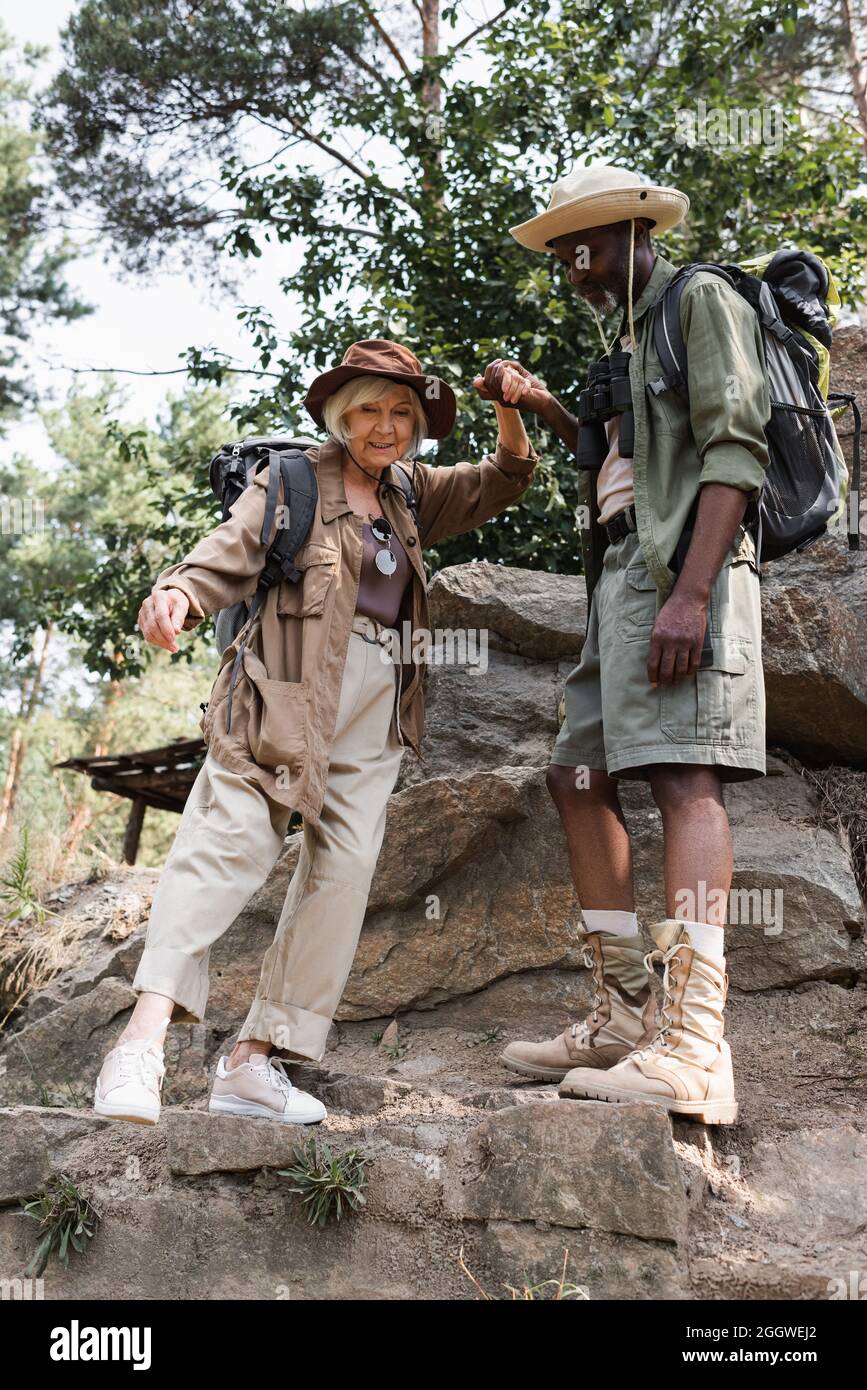 Ältere Wanderer mit gemischter Beteiligung an Steinen im Wald Stockfoto