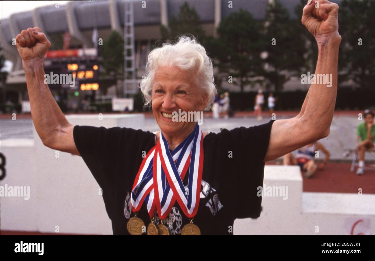 Baton Rouge Louisiana USA, 1993: Frau, die beim 74-70-jährigen Altersgruppenwettbewerb beim U.S. Senior Sports Classic vier Goldmedaillen gewonnen hat, feiert außerhalb des Rennstadions. ©Bob Daemmrich Stockfoto