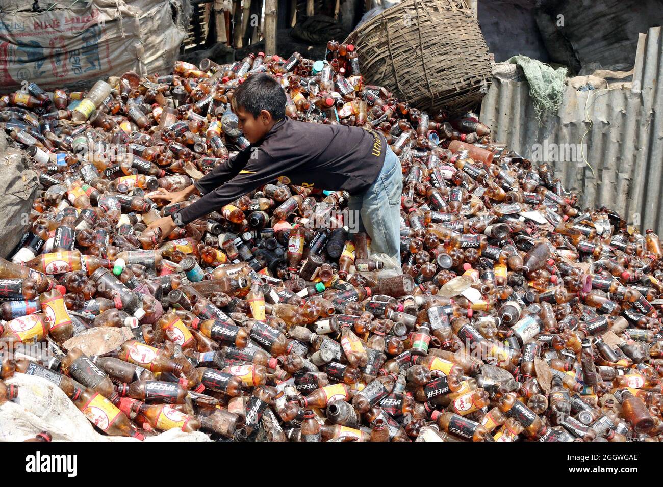 Dhaka, Bangladesch, 03/09/2021, Ein Kind trennt Flaschen aus Polyethylenterephthalat (PET) in einer Recyclingfabrik am Stadtrand von Dhaka. Das Recycling von Kunststoffflaschen hat sich in den letzten Jahren zu einem wachsenden Geschäft entwickelt und trägt zum Schutz der Umwelt bei. Nach Angaben der Bangladesh PET Flakes Manufacturers and Exporters Association (BPFMEA) exportiert Bangladesch durchschnittlich fast 30,000 Tonnen PET-Flaschenflocken im Wert von ca. Millionen Dollar pro Jahr hauptsächlich nach China, Südkorea und Taiwan. Am 3. September 2021. (Foto von Habibur Rahman / Eyepix Group) Stockfoto