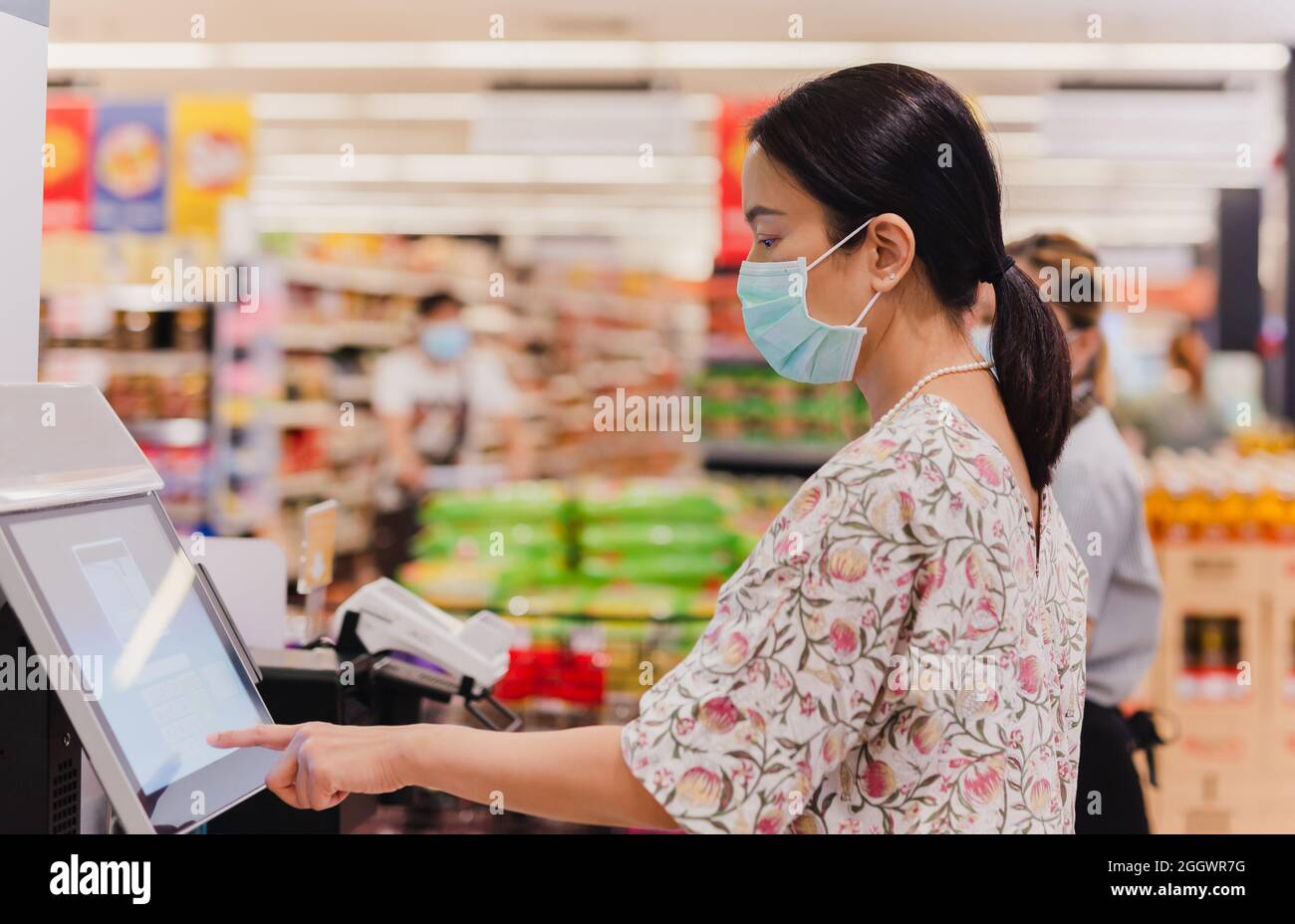 Kaukasische Frau benutzt einen Selbstbedienungsschalter im Supermarkt. Stockfoto