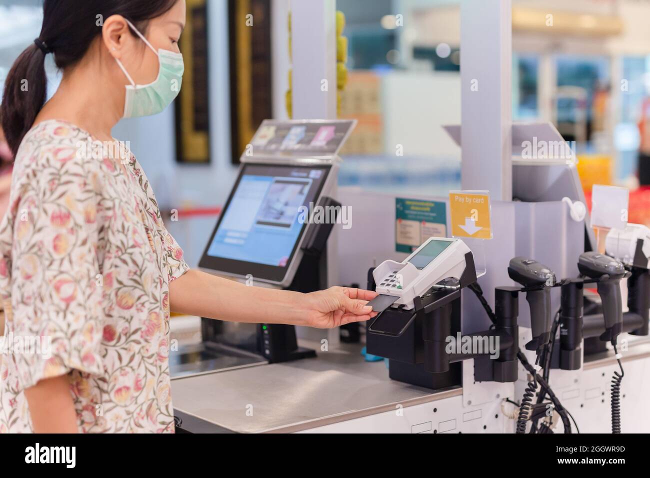 Frau mit Bankkarte, die Essen im Supermarkt selbst-Check-out bezahlt. Stockfoto