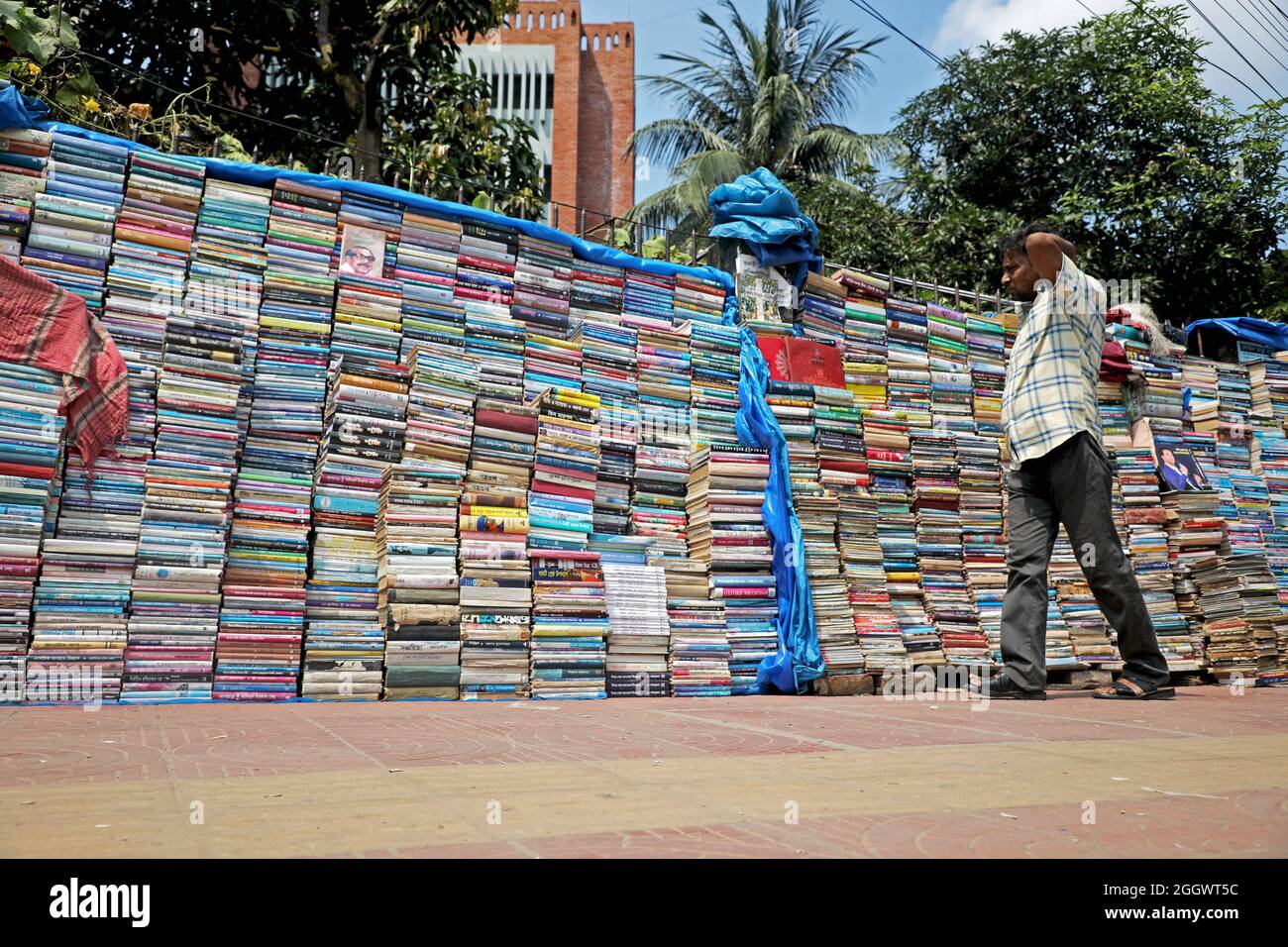 Dhaka, Bangladesch. September 2021. Ein Mann sieht aus, wie viele Bücher aufgestapelt wurden, die aufgrund der Schließung von Buchhandlungen aufgrund mangelnder Verkäufe aufgrund der Covid-19-Situation zu sehr niedrigen Preisen auf dem externen Markt versteigert wurden. Die alten Buchhandlungen in der Hauptstadt Newmarket haben aufgrund der Schließung von Bildungseinrichtungen aufgrund der Prävalenz von Covid-19 lange Zeit Verluste erlitten. Am 3. September 2021 in Dhaka, Bangladesch. Kredit: Eyepix Gruppe/Alamy Live Nachrichten Gutschrift: Eyepix Gruppe/Alamy Live Nachrichten Stockfoto