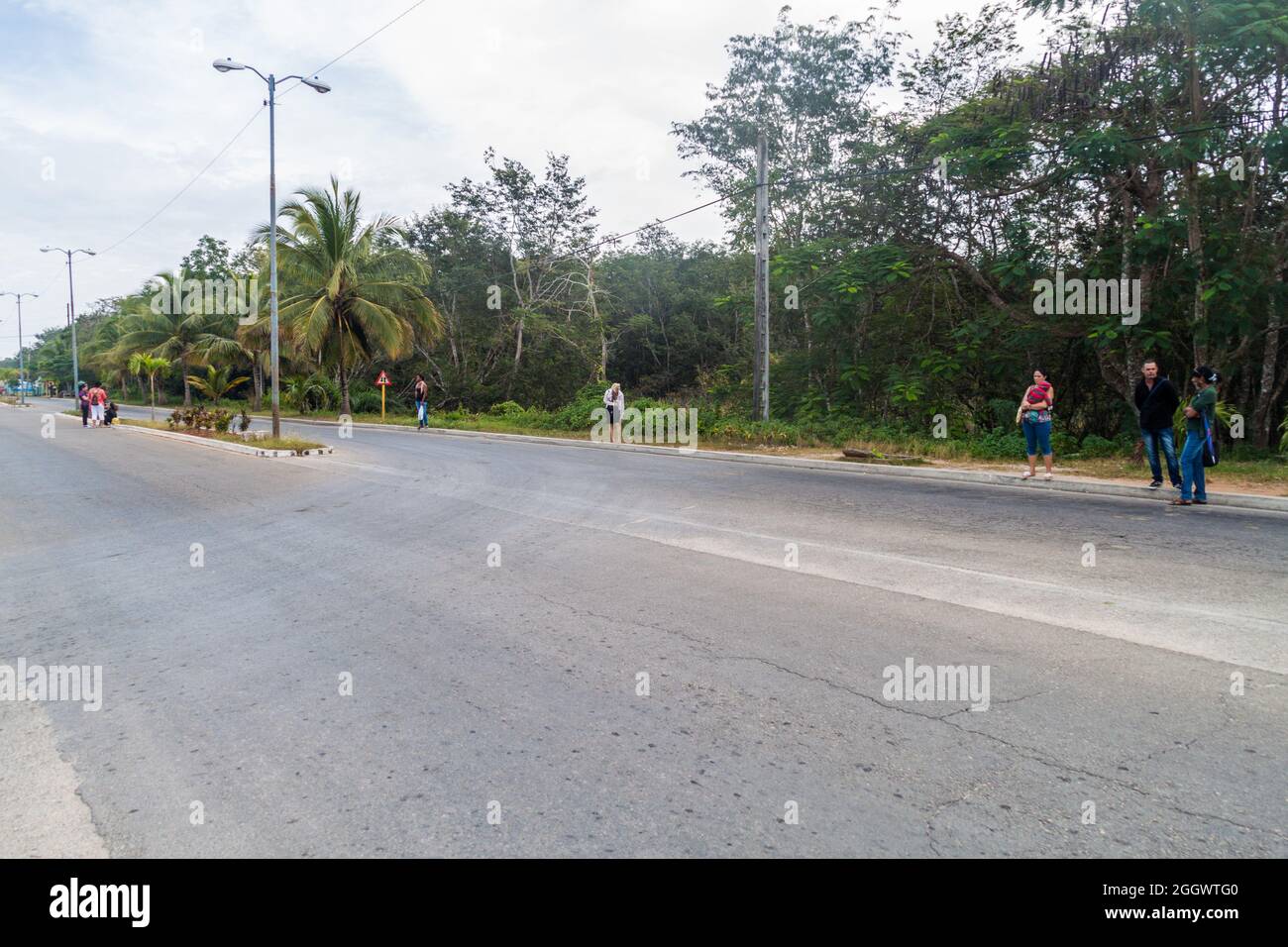 PLAYA LARGA, KUBA - 16. FEB 2016: Anhalter warten an einem Straßenrand im Dorf Playa Larga, Kuba. Stockfoto