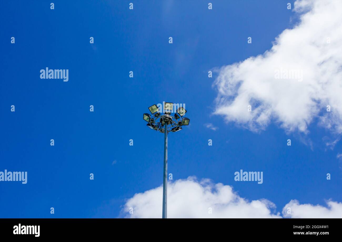 Eine Leuchtlampe auf einer Stange gegen den blauen Himmel, Sportlicht mit blauem Himmel Wolke Hintergrund Stockfoto