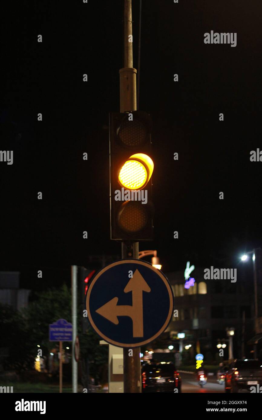 Ampel mit gelber Ampel, Straßenschild links abbiegen und Schieß los. in der Stadt. Stockfoto