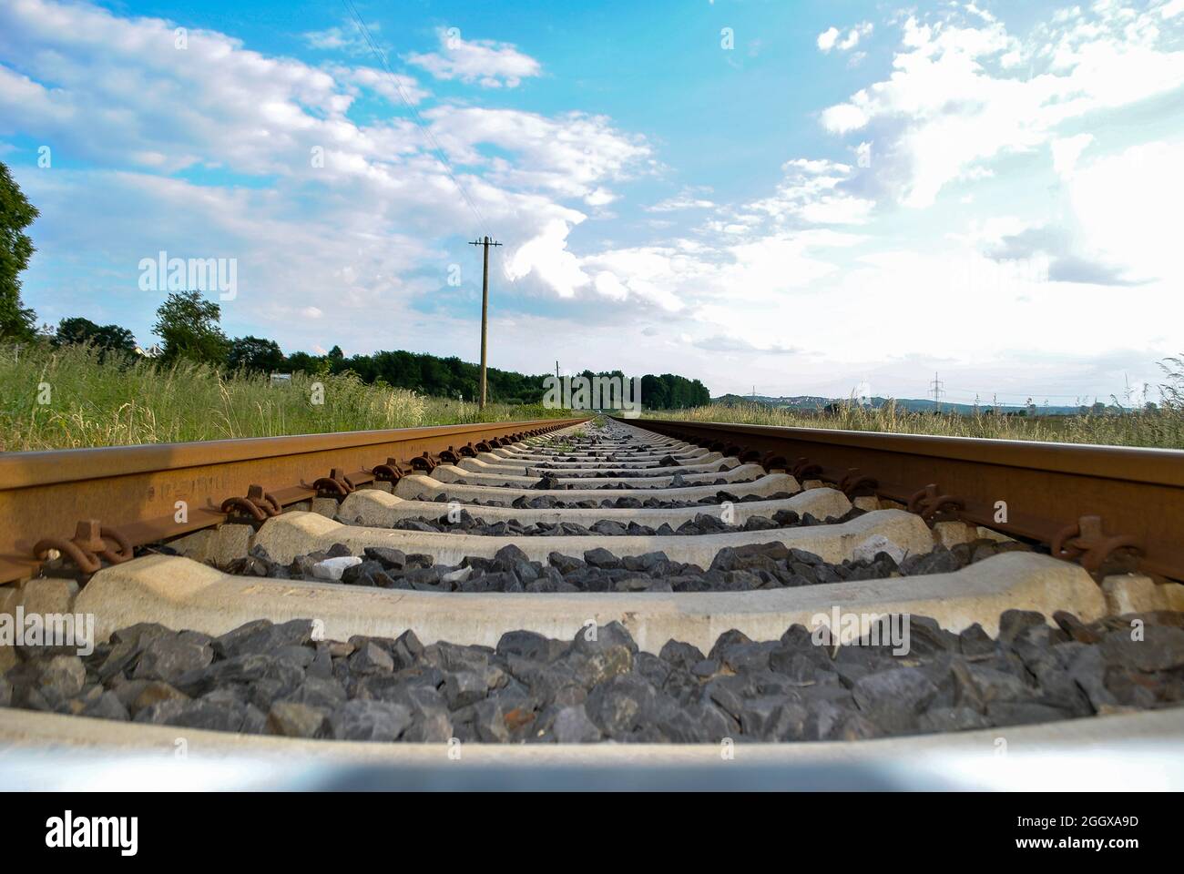 Eisenbahnschienen und -schweiner schossen tief über dem Boden aus nächster Nähe auf einem Hintergrund wolkigen Himmels Stockfoto