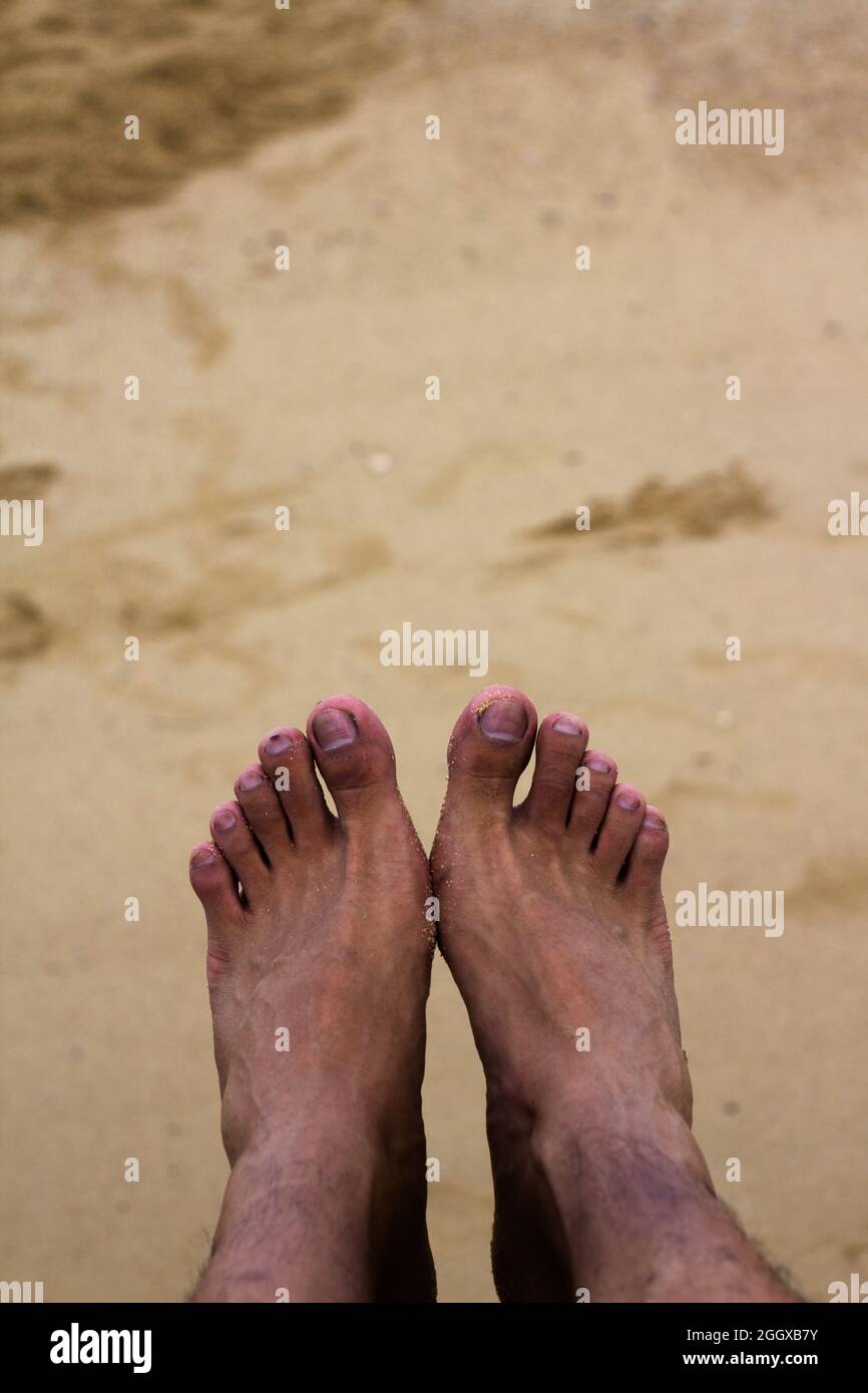 Eines Tages in den Sommerferien, Mann Füße auf dem Strand Sand Stockfoto
