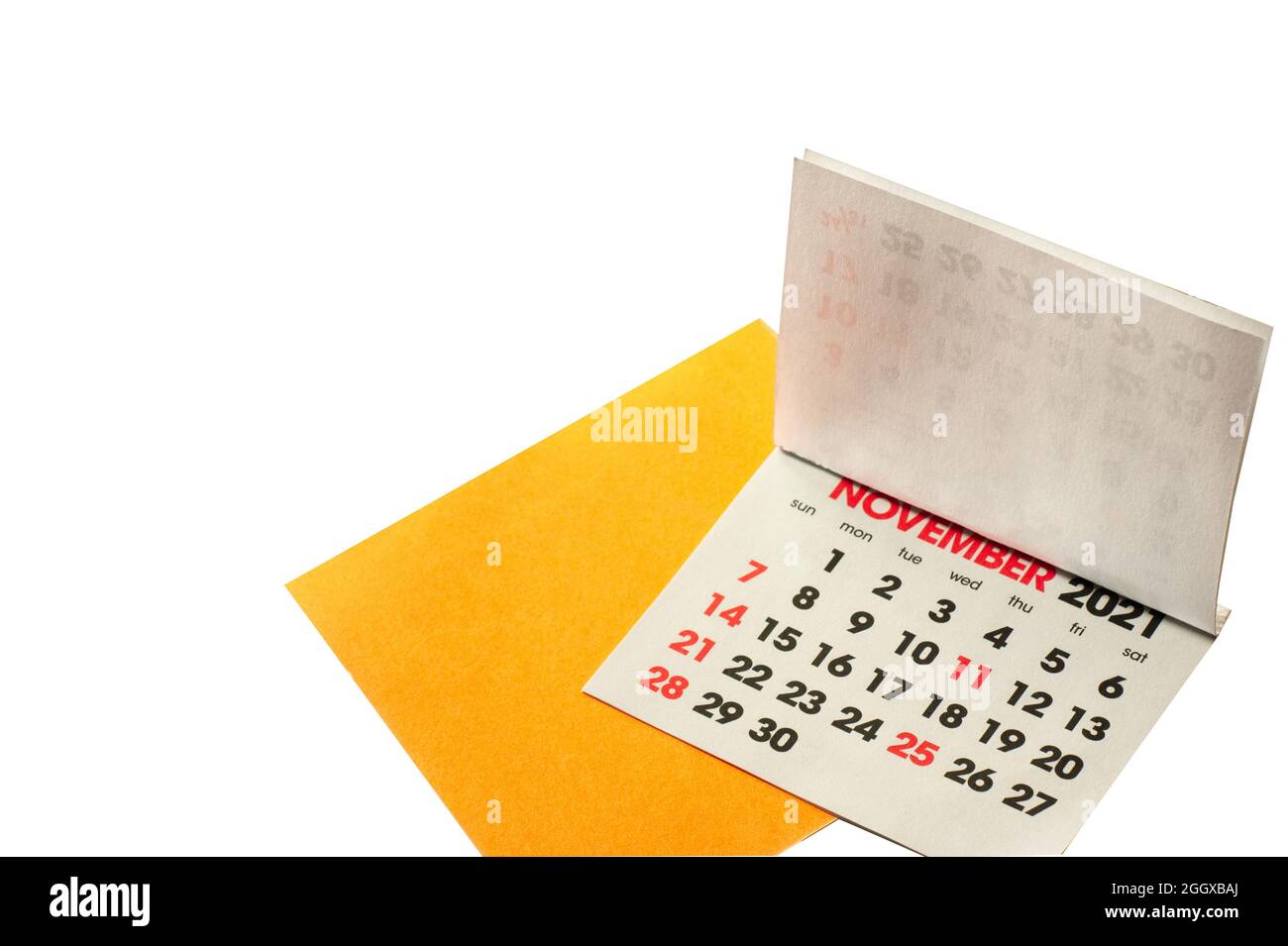 November 2021 Kalender mit gelbem Erinnerungsnotepapier isoliert. Die Kalenderseiten werden nach vorne gedreht, um den November in Rot zu betonen. Stockfoto