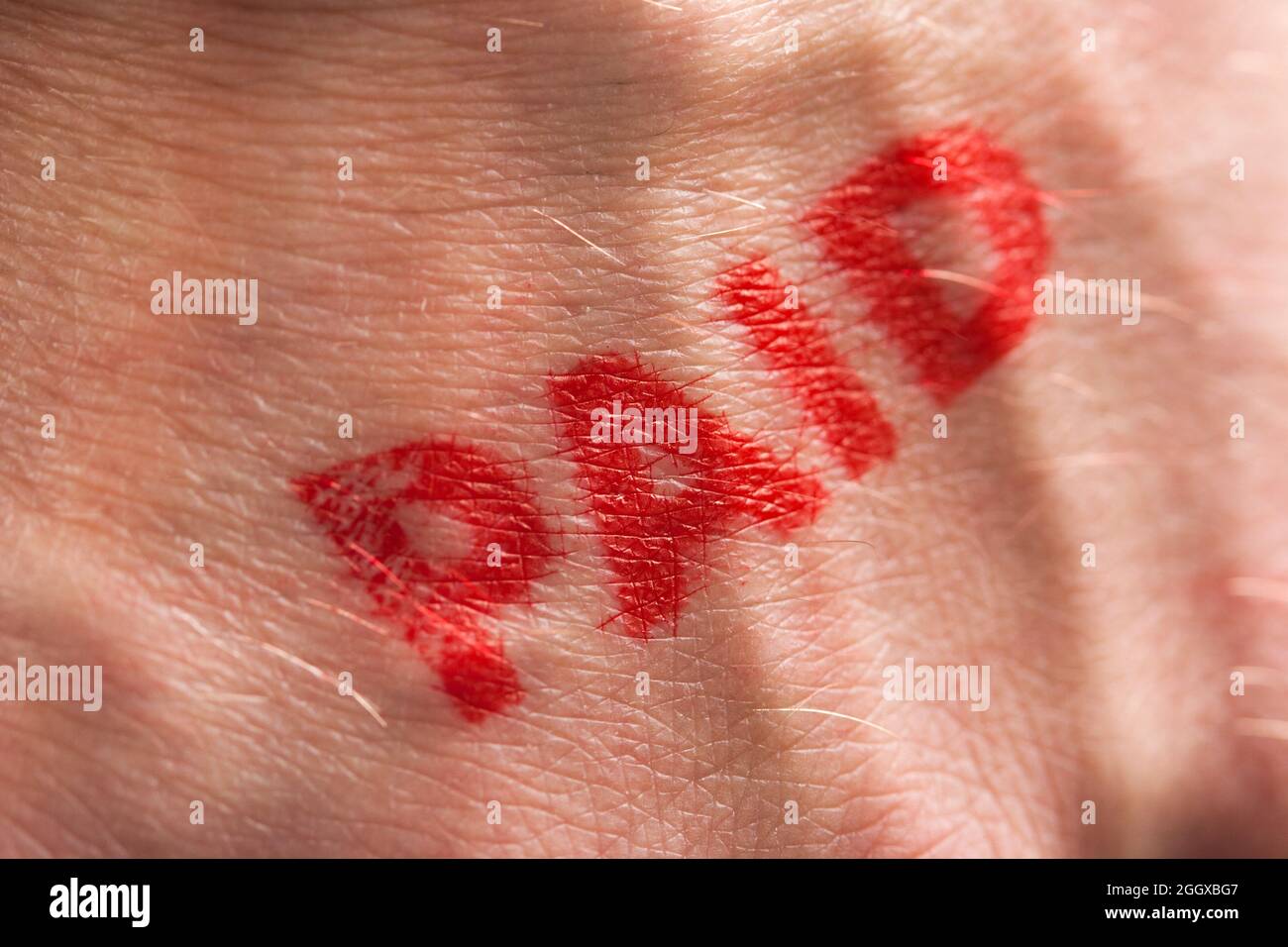 Roter Tintenstempel mit dem Wort, das auf dem Handrücken bezahlt wird Stockfoto