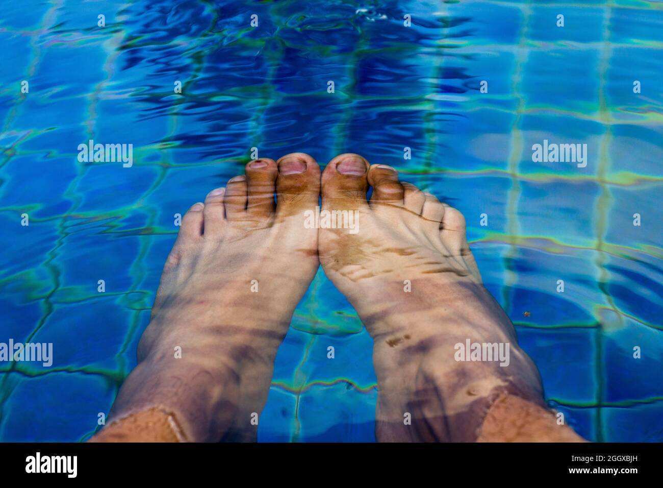 Entspannen Sie sich Zeit, Mann Füße in den Pool unter dem Wasser Stockfoto