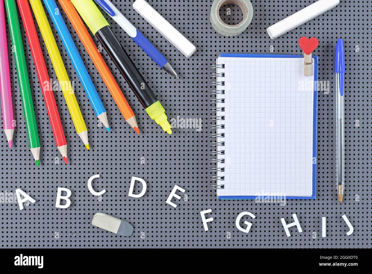 Notizblock auf Spirale, Schulmaterial und Buchstaben des englischen Alphabets. Schulkonzept. Stockfoto