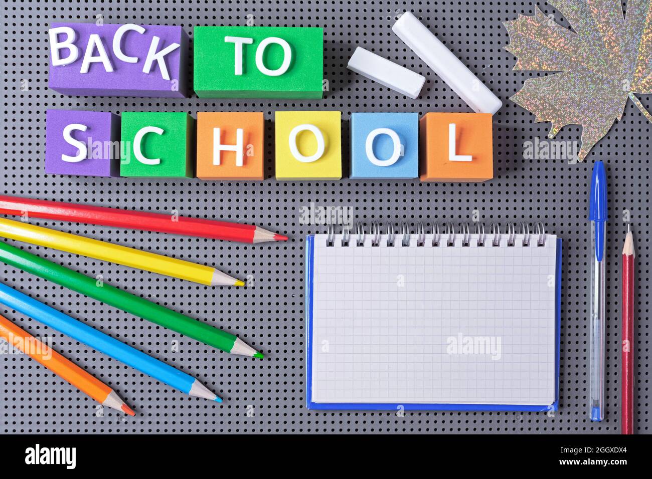 Bunte Würfel mit der Aufschrift 'Back to School' und Schulbedarf. Schulkonzept. Stockfoto