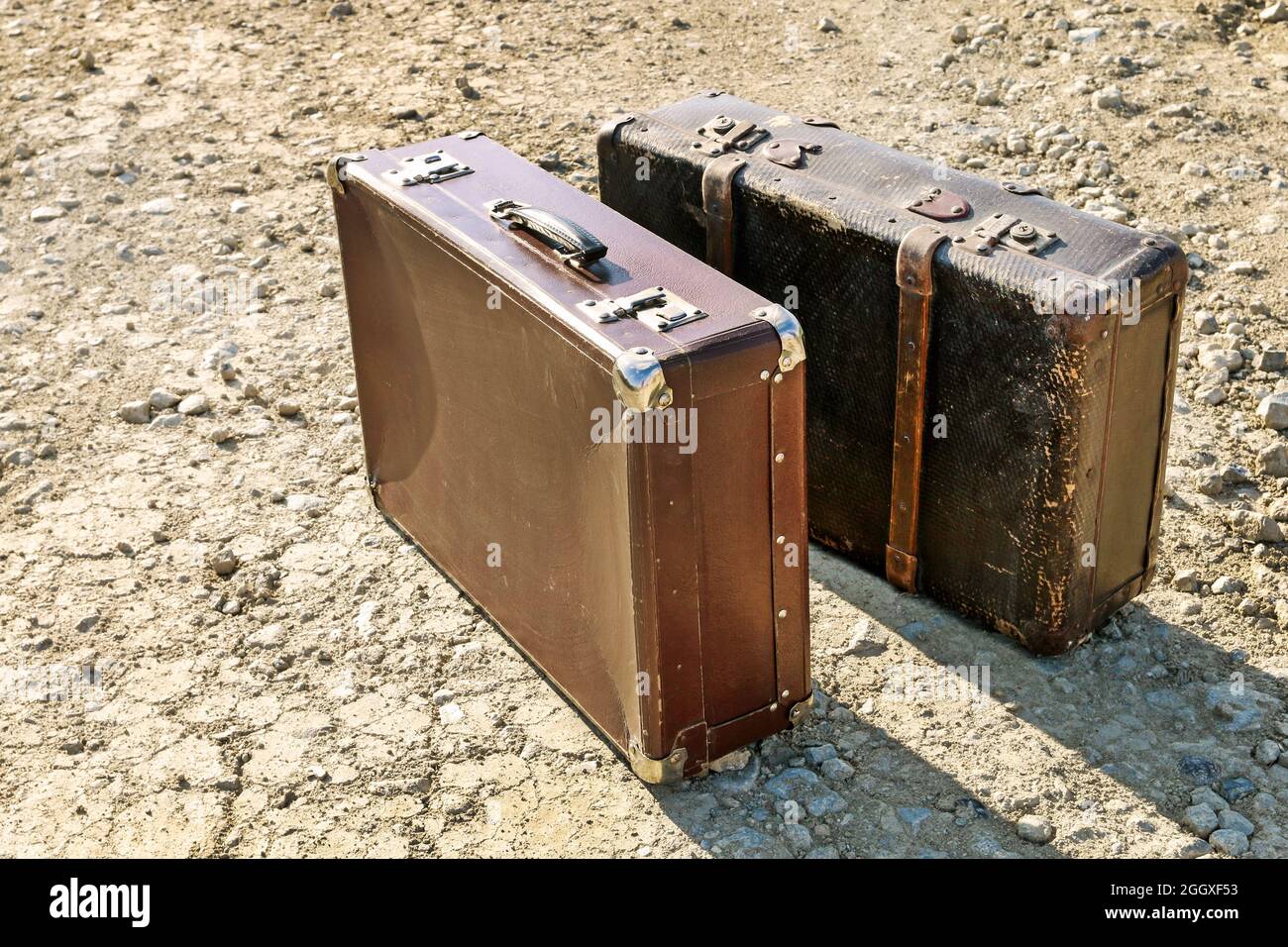 Zwei alte Koffer auf trockenem Boden. Konzeptuelles Image. Stockfoto