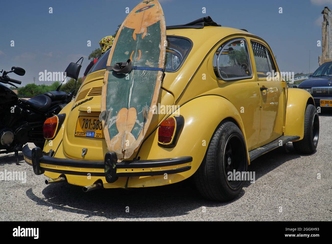 TEL AVIV, ISRAEL - 23. Jul 2021: Nahaufnahme eines gelben Volkswagen-Käfers mit einem Skateboard auf der Rückseite in Tel Aviv, Israel Stockfoto