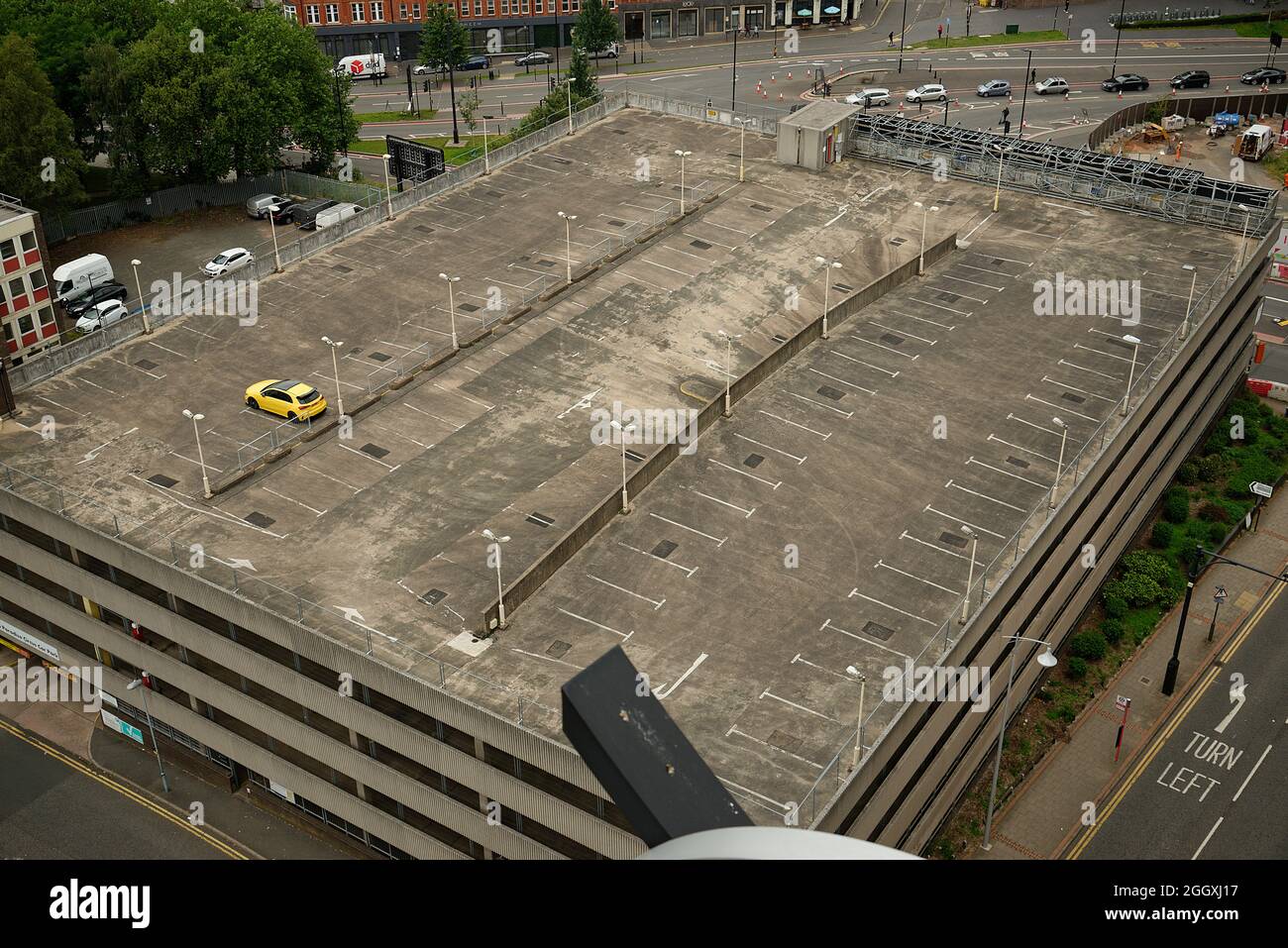 Ein fast leerer Parkplatz in Birmingham. Ein einstöckiges, hellgelbes Auto im obersten Stock. Stockfoto