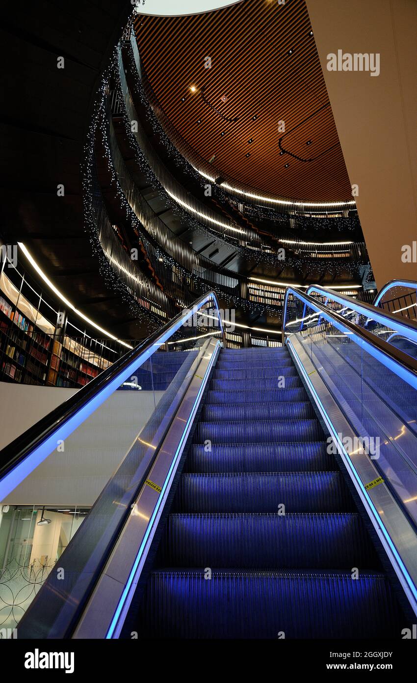 Bibliothek von Birmingham, im Zentrum der Stadt West Midlands. Gebogenes Atrium und blau beleuchtete Rolltreppen und funkelndes Licht. Stockfoto